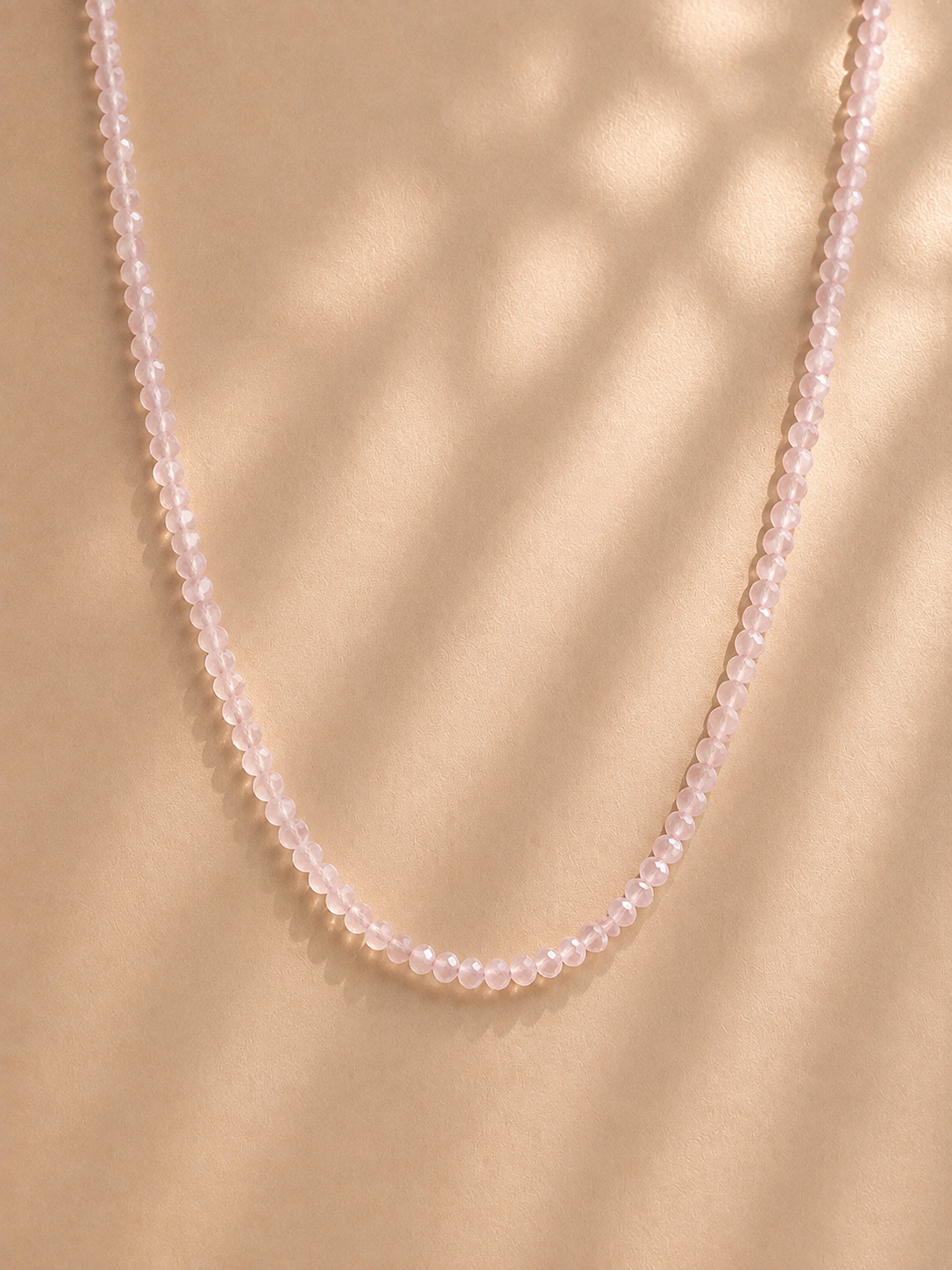 Řetízek Rose Quartz Minimla na béžovém pozadí.